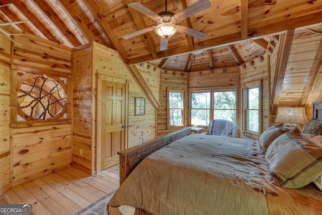 bedroom with lofted ceiling with beams, wood ceiling, wood walls, light hardwood / wood-style flooring, and ceiling fan