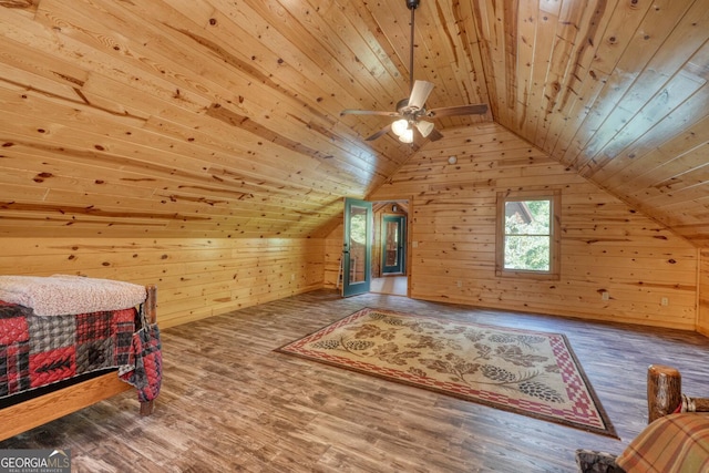 interior space featuring hardwood / wood-style flooring, wood walls, vaulted ceiling, and wooden ceiling