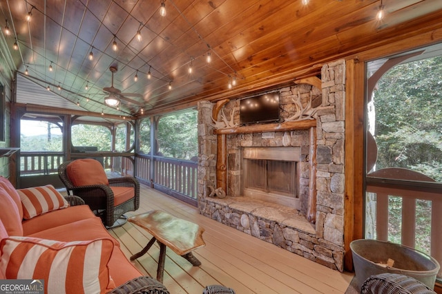 living room featuring ceiling fan, a fireplace, light hardwood / wood-style floors, and a healthy amount of sunlight