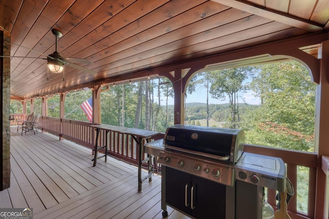 wooden deck with ceiling fan and grilling area