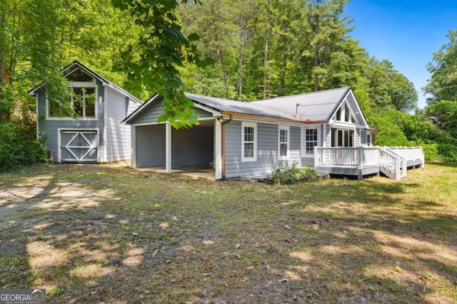 rear view of house with a storage shed and a deck