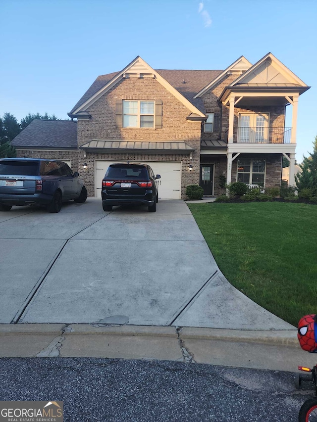 view of front facade with a balcony, a front yard, and a garage