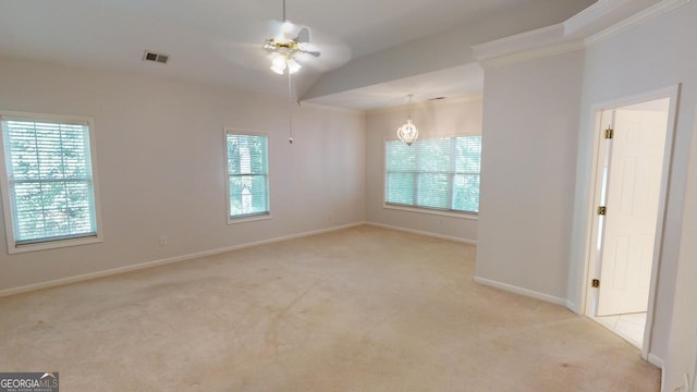 carpeted spare room featuring ceiling fan, a healthy amount of sunlight, and crown molding