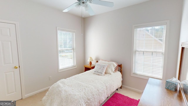 bedroom with ceiling fan, light carpet, and multiple windows