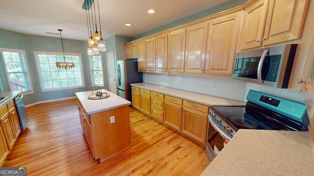 kitchen with a chandelier, a center island, hanging light fixtures, light hardwood / wood-style flooring, and appliances with stainless steel finishes