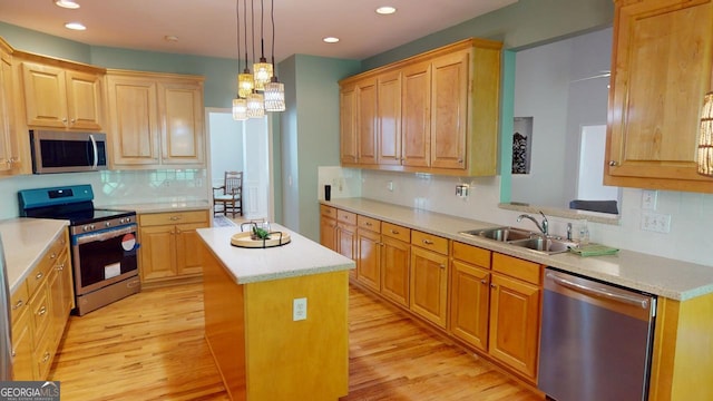 kitchen with appliances with stainless steel finishes, light hardwood / wood-style floors, tasteful backsplash, and a center island