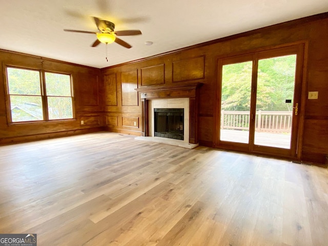 unfurnished living room featuring light wood-type flooring, ceiling fan, and plenty of natural light