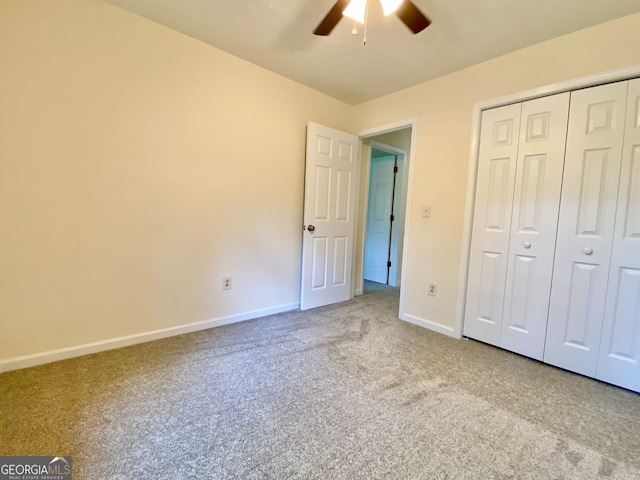 unfurnished bedroom featuring ceiling fan, a closet, and carpet