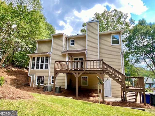 back of property featuring cooling unit, a deck, and a yard