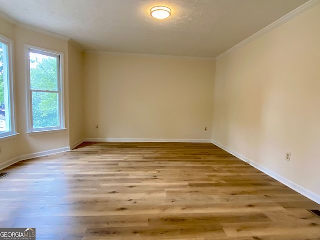 unfurnished room featuring crown molding and light hardwood / wood-style floors