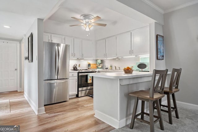 kitchen featuring stainless steel appliances, light wood-type flooring, and white cabinets