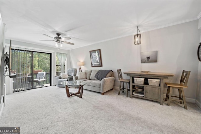 living room featuring ceiling fan, ornamental molding, and carpet floors