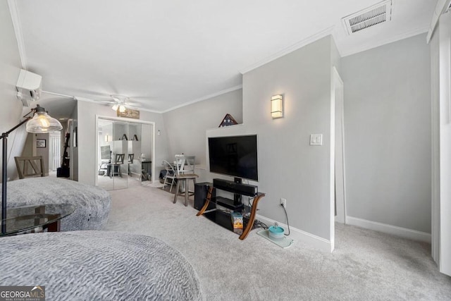 carpeted bedroom featuring a closet, crown molding, and ceiling fan