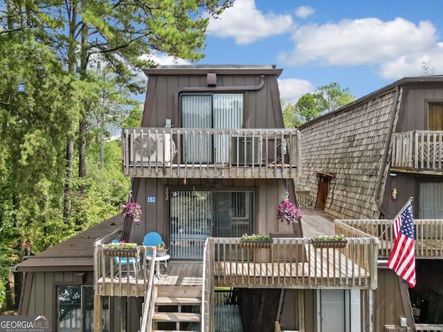 rear view of property with a wooden deck and a balcony