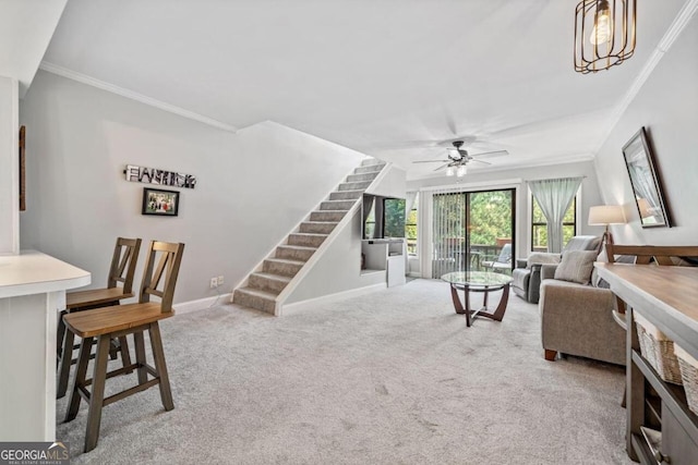 carpeted living room with ceiling fan and crown molding