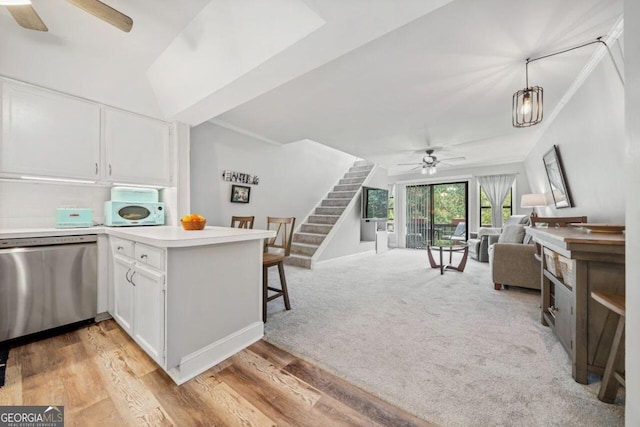 kitchen featuring white cabinetry, light wood-type flooring, stainless steel dishwasher, and ceiling fan