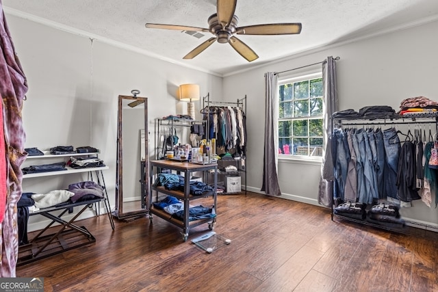 interior space with a textured ceiling, wood-type flooring, ornamental molding, and ceiling fan