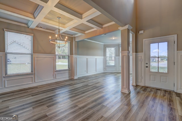 entryway featuring a wealth of natural light, a chandelier, hardwood / wood-style floors, and ornate columns