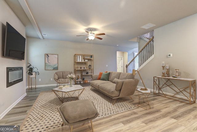 living room featuring hardwood / wood-style floors and ceiling fan