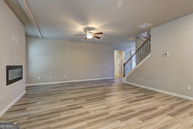 unfurnished living room with heating unit, light hardwood / wood-style floors, and ceiling fan