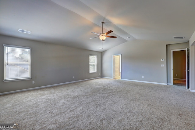 carpeted spare room featuring ceiling fan and vaulted ceiling