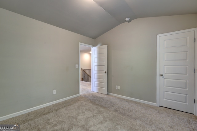 interior space with light carpet and lofted ceiling