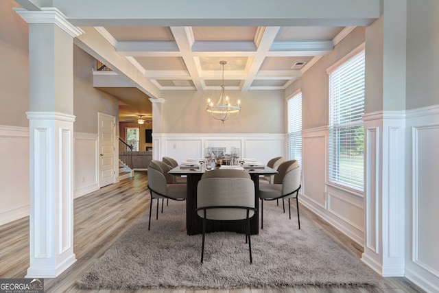 dining room featuring light hardwood / wood-style floors, decorative columns, beam ceiling, and a wealth of natural light