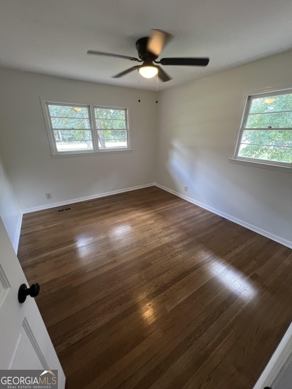 spare room with ceiling fan and dark hardwood / wood-style flooring