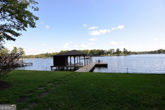 view of dock with a water view and a yard