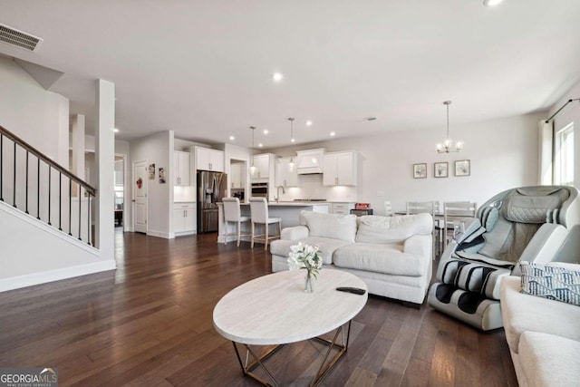 living room featuring dark hardwood / wood-style flooring, sink, and a notable chandelier