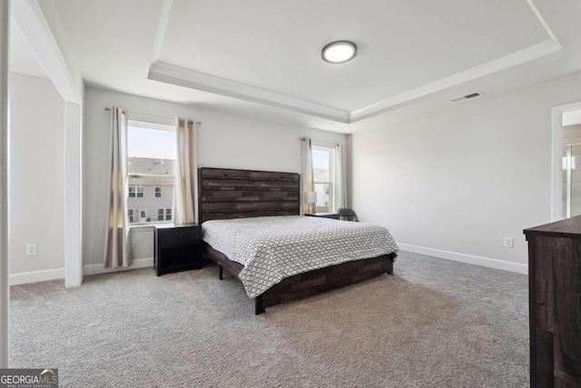 bedroom featuring light carpet and a raised ceiling