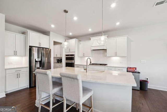 kitchen featuring white cabinets, appliances with stainless steel finishes, hanging light fixtures, and dark hardwood / wood-style flooring