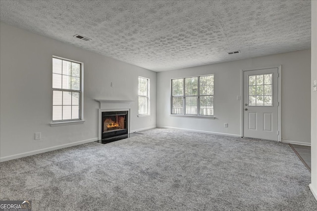 unfurnished living room with a textured ceiling and carpet flooring