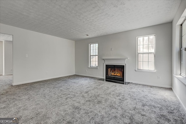 unfurnished living room featuring a textured ceiling and carpet