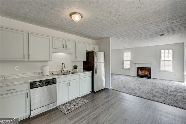 kitchen featuring wood-type flooring, white cabinetry, appliances with stainless steel finishes, and sink