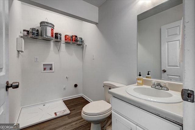 bathroom featuring wood-type flooring, vanity, and toilet