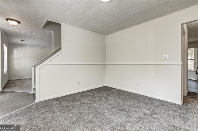 carpeted empty room featuring a textured ceiling