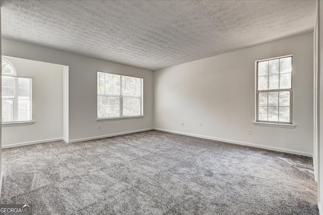 spare room featuring a textured ceiling and carpet floors