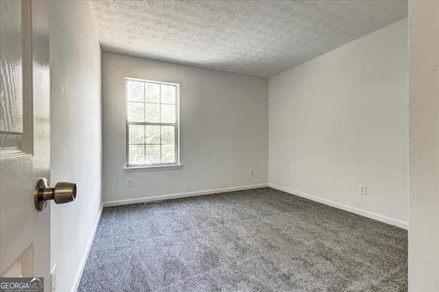 carpeted empty room with a textured ceiling