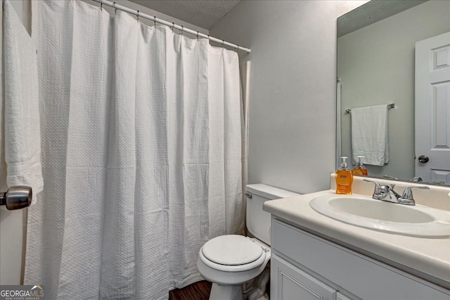 bathroom featuring a shower with curtain, a textured ceiling, vanity, and toilet