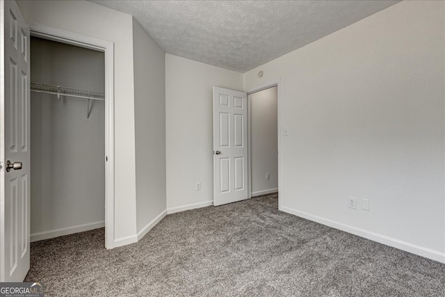 unfurnished bedroom featuring a textured ceiling, a closet, and carpet