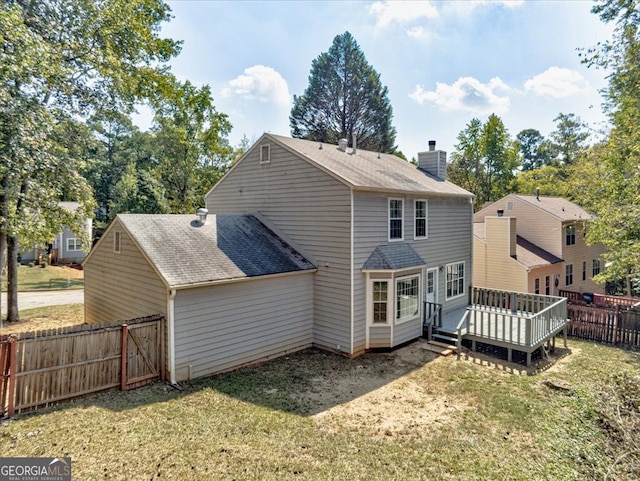 back of property with a lawn and a deck