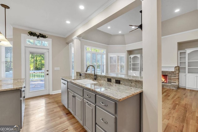 kitchen with gray cabinets, light hardwood / wood-style floors, a fireplace, and sink