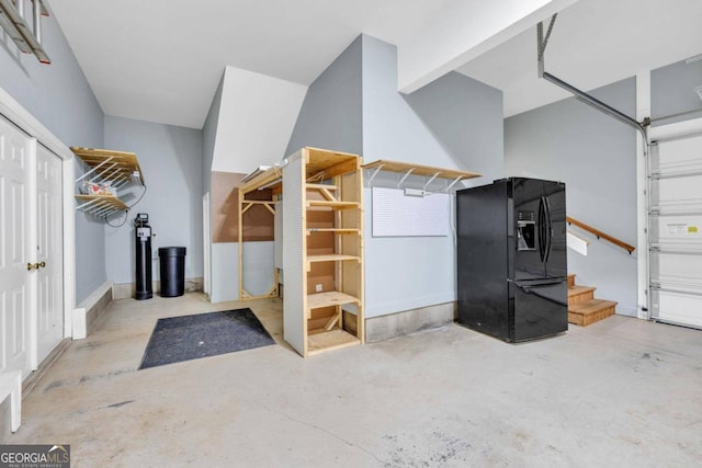 interior space with black fridge with ice dispenser