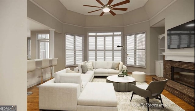 living room featuring a towering ceiling, ceiling fan, a fireplace, and hardwood / wood-style floors