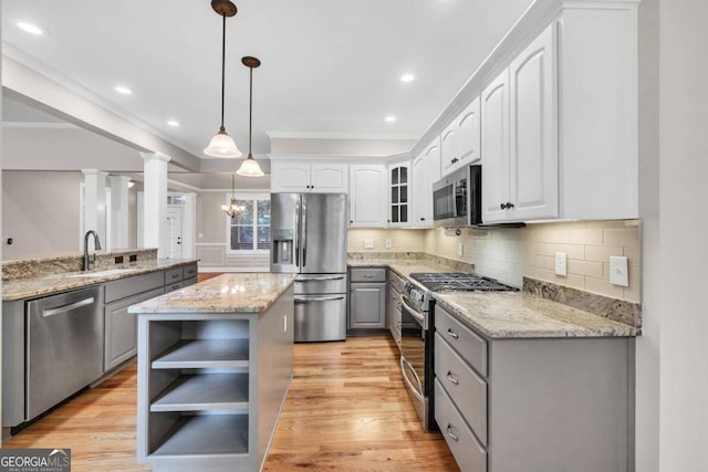 kitchen featuring gray cabinetry, light hardwood / wood-style floors, stainless steel appliances, ornate columns, and sink