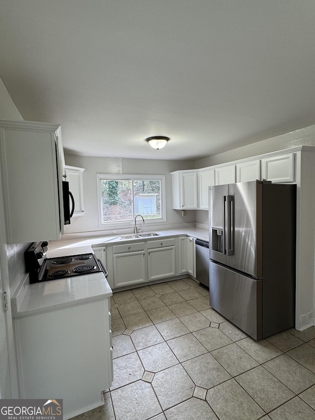 kitchen featuring stainless steel appliances, white cabinetry, sink, and light tile patterned floors