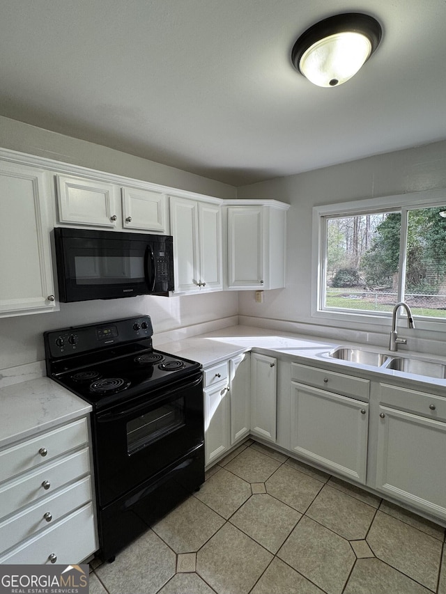 kitchen with white cabinets, light tile patterned floors, sink, and black appliances