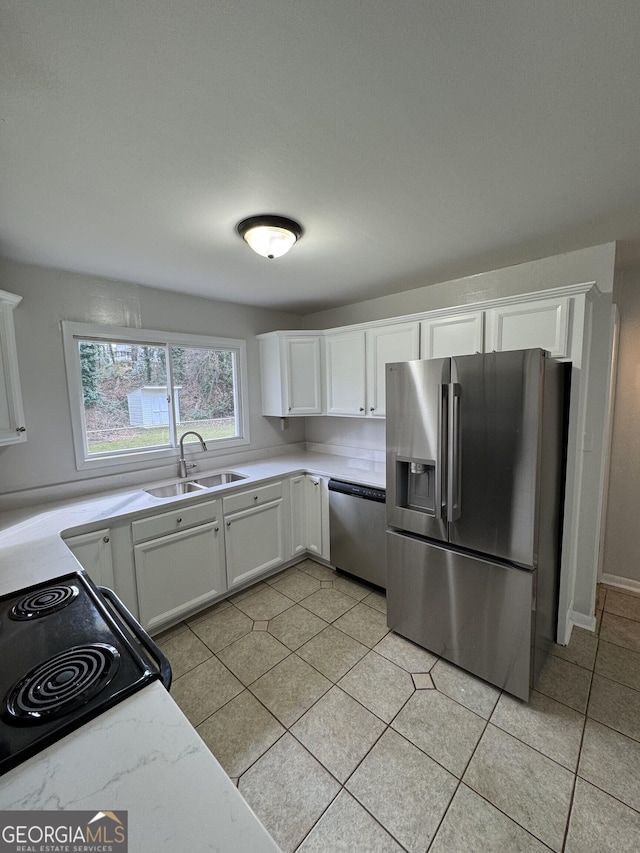 kitchen with white cabinetry, stainless steel appliances, sink, and light tile patterned floors