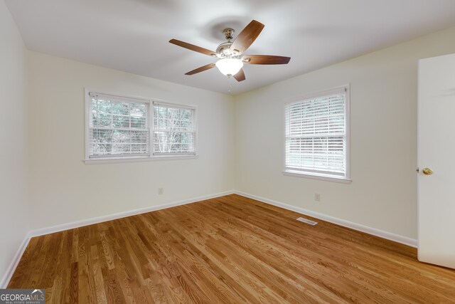 unfurnished room with ceiling fan, a healthy amount of sunlight, and light wood-type flooring